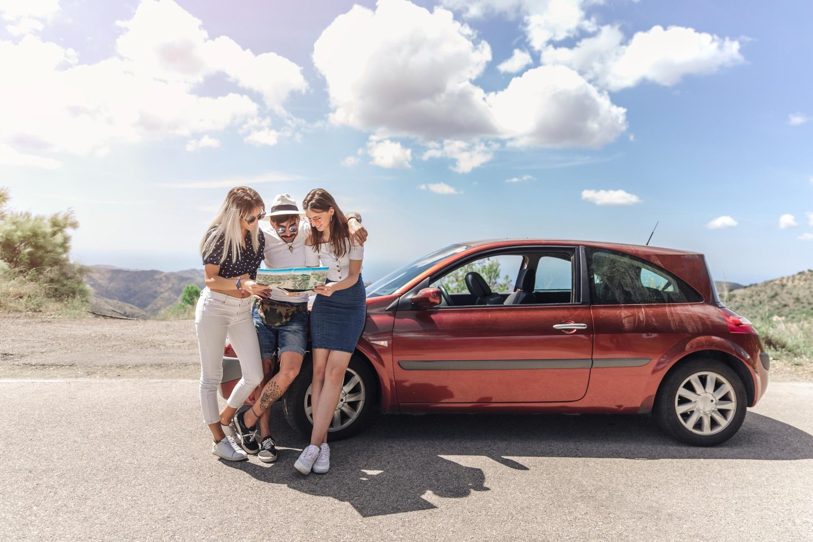 three-friends-looking-map-standing-near-modern-car-road